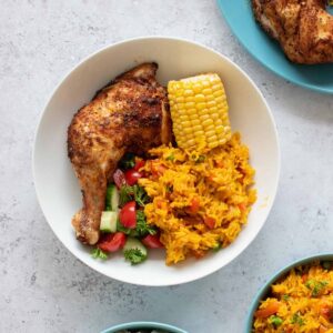 Peri peri chicken with rice, corn on the cob and salad.