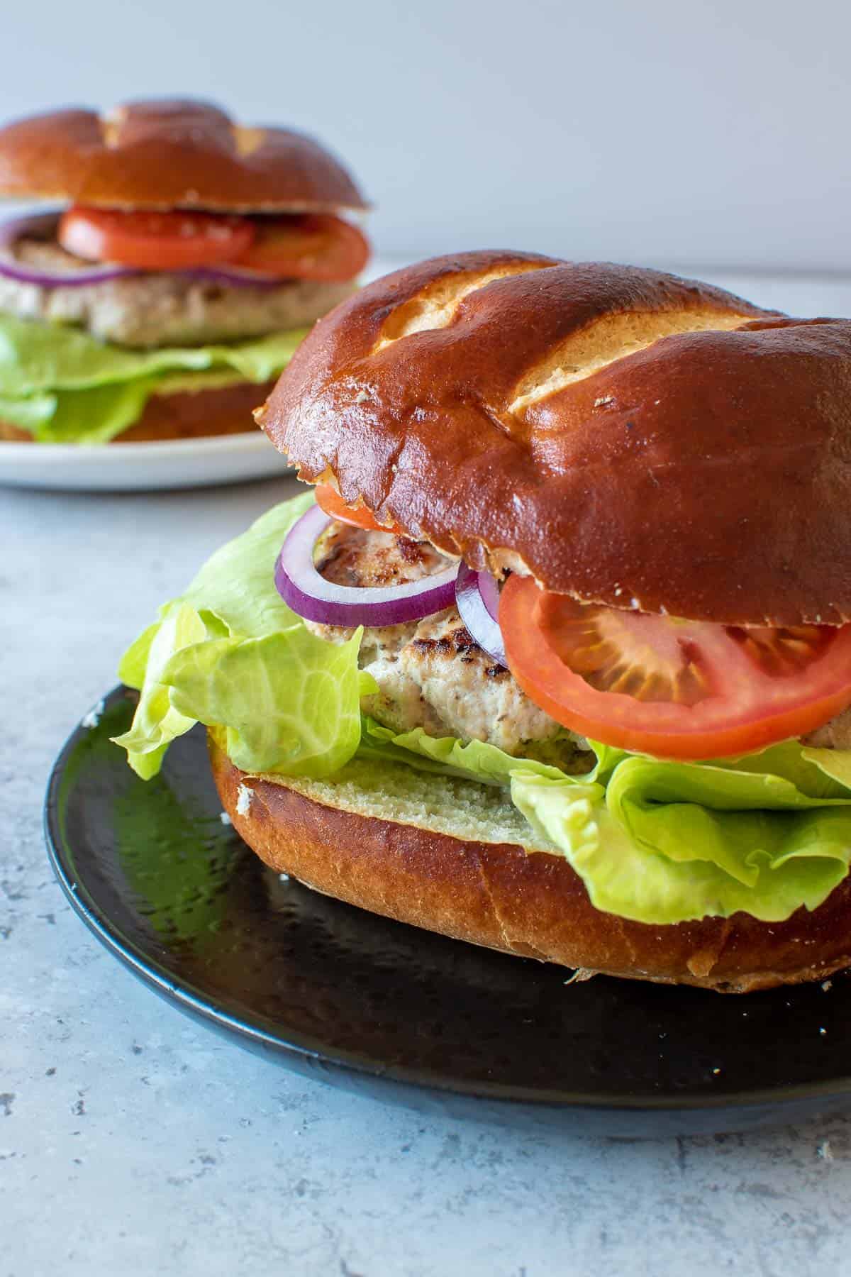 Two plated pork burgers.