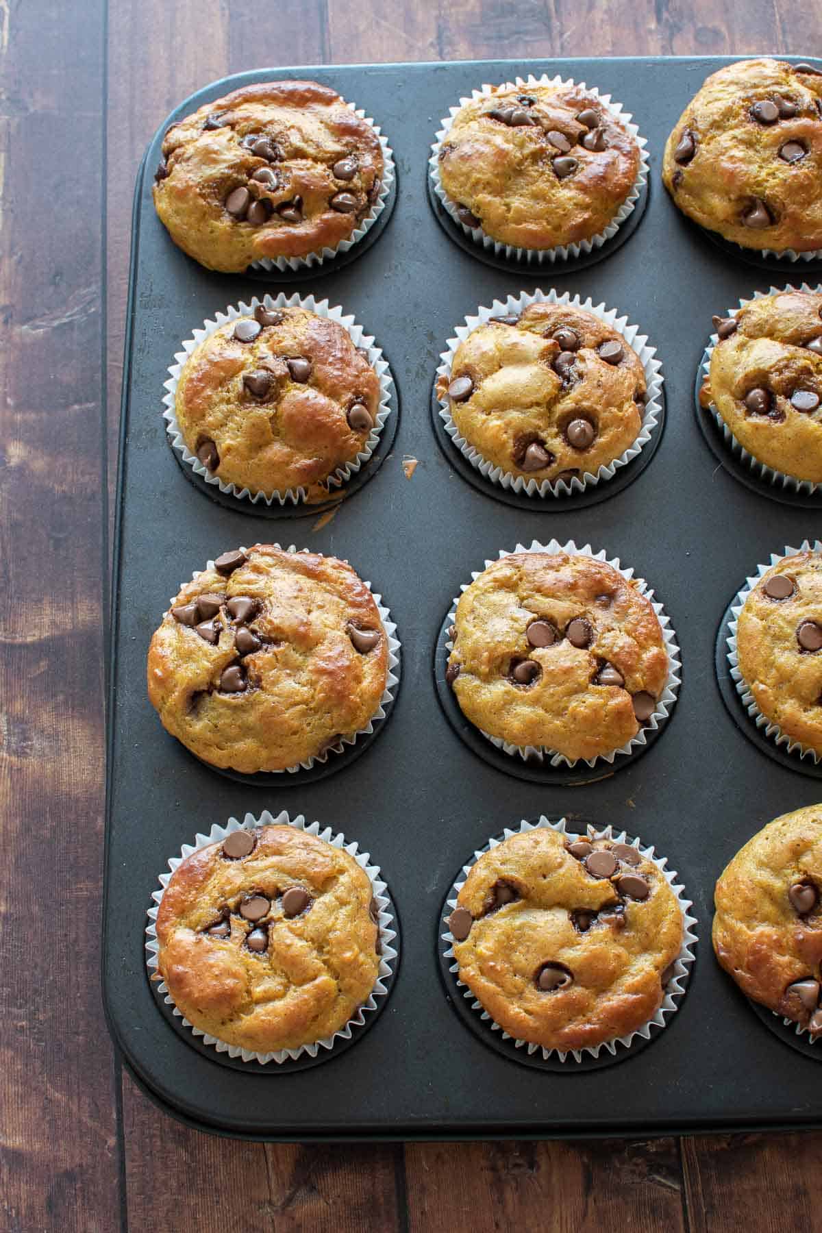 Baked pumpkin muffins in a muffin pan.