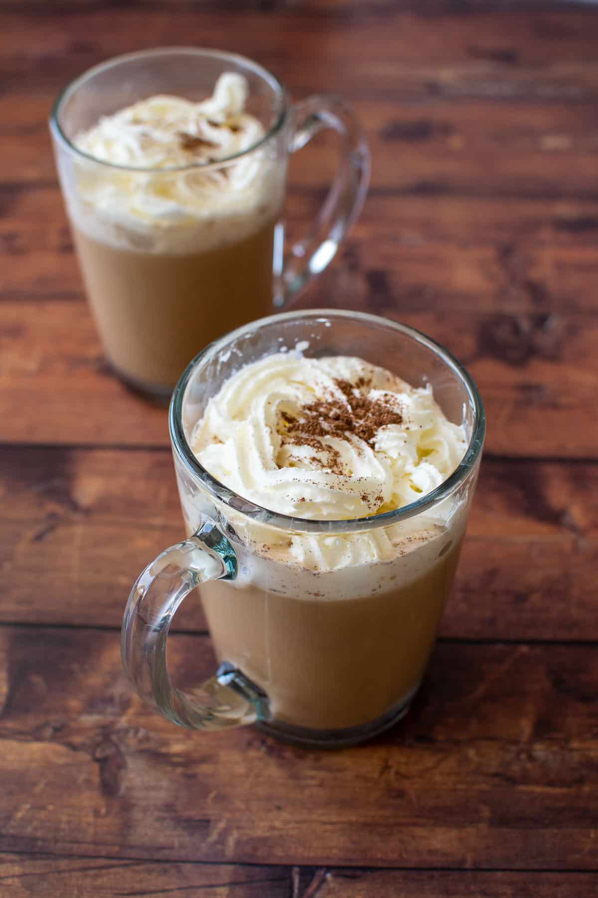 Two cups of latte with whipped cream.