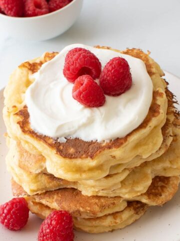 Quark pancakes topped with quark and raspberries.