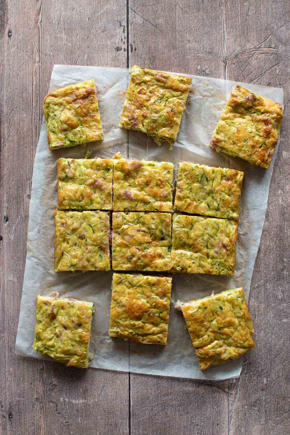 Sliced zucchini and bacon slices on a table.