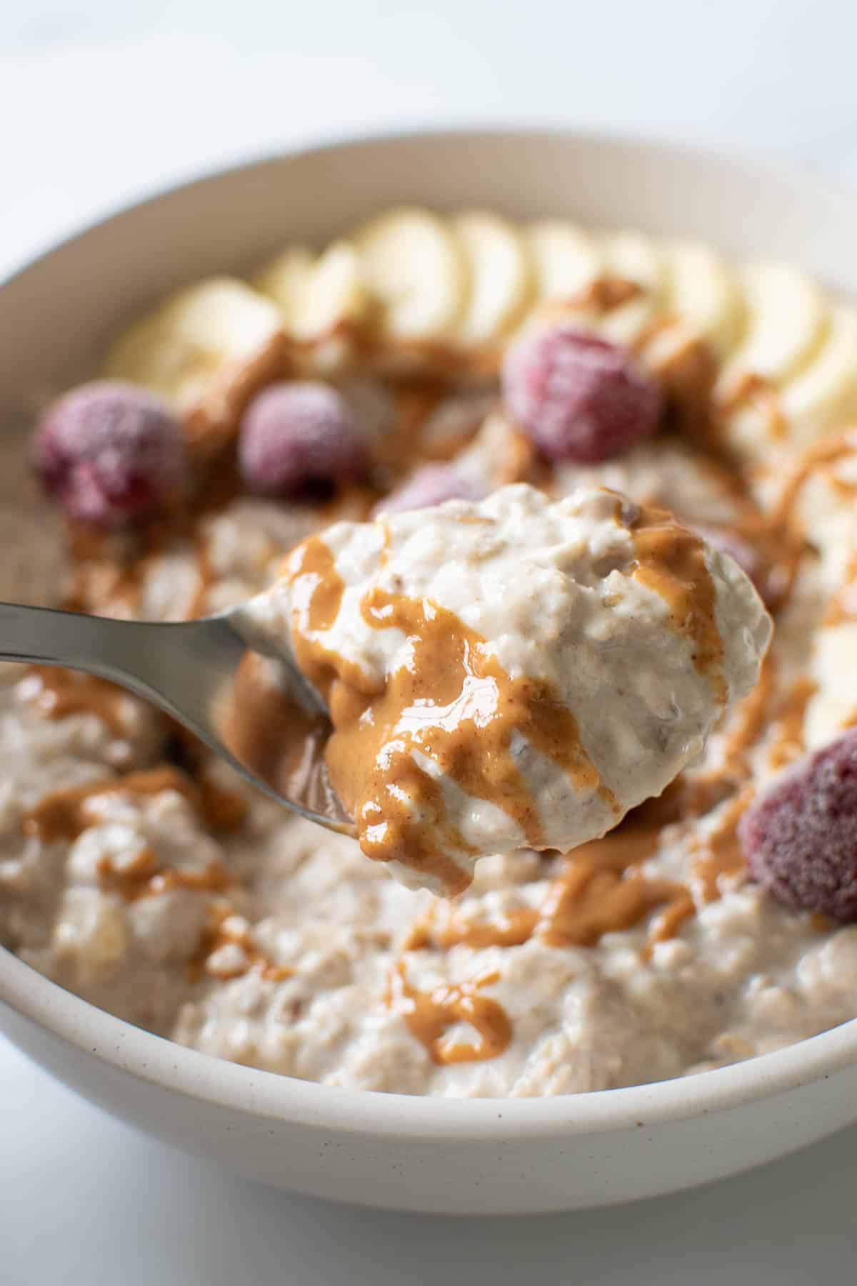 Close up of a spoon filled with peanut butter banana overnight oats.