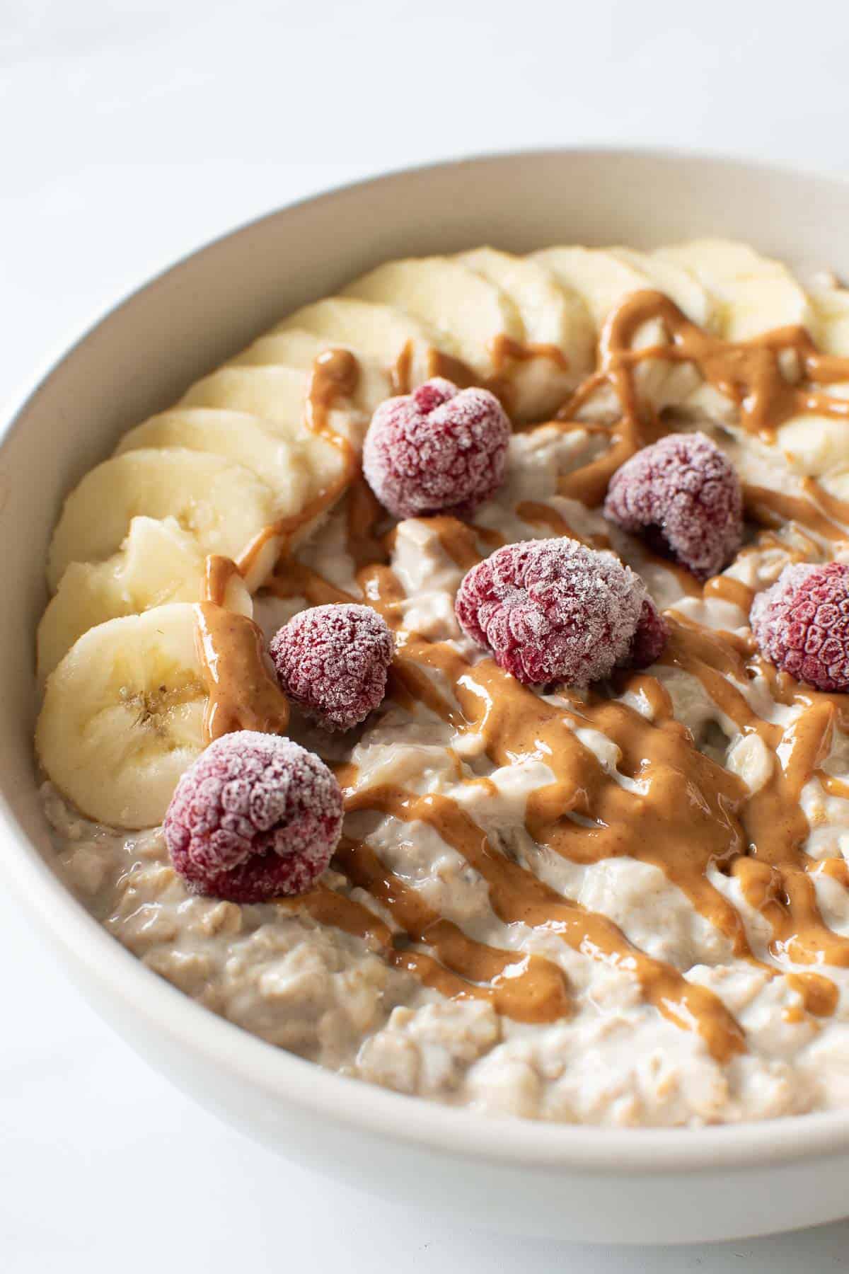 A bowl of creamy oats with bananas and peanut butter.