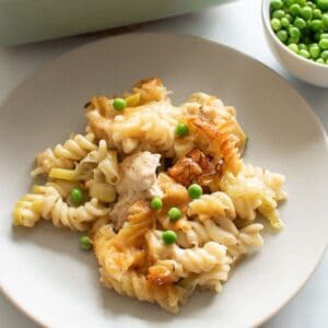 Pasta bake with chicken, leek and peas on a plate.