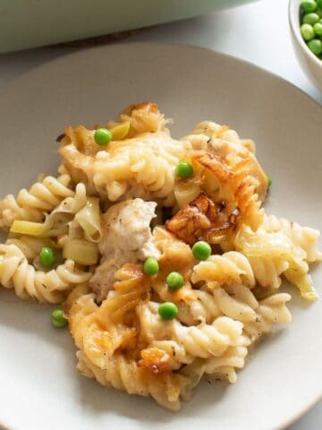 Pasta bake with chicken, leek and peas on a plate.