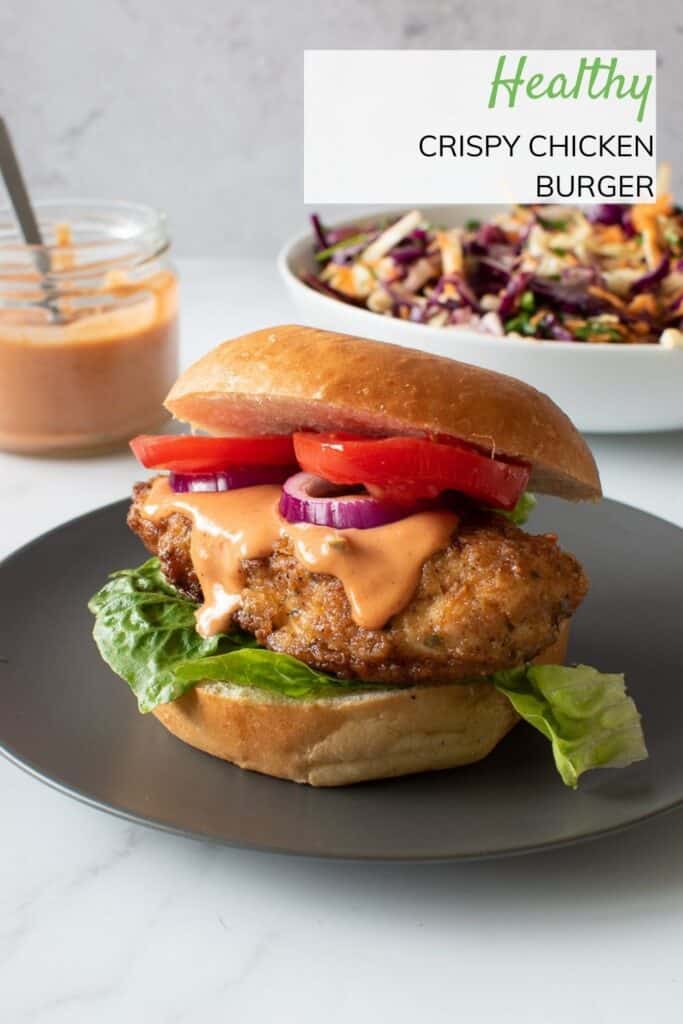 A chicken burger with lettuce, tomatoes, burger sauce and onion.