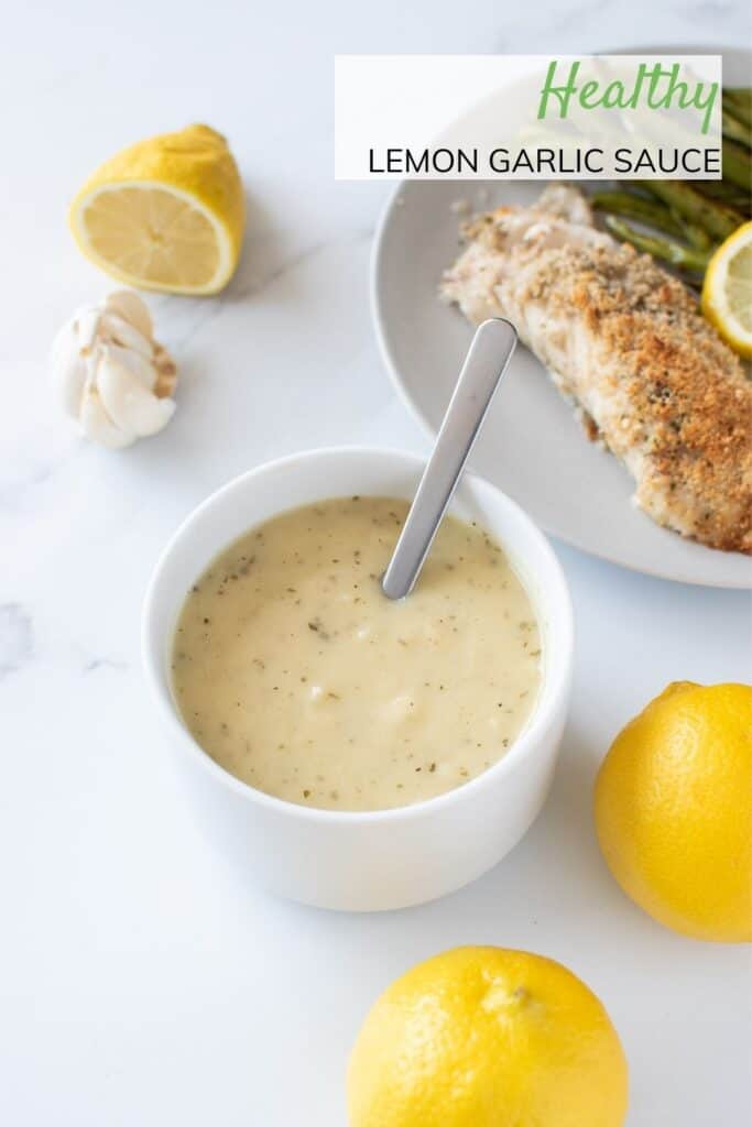 A bowl of lemon and garlic sauce with lemon on the side.