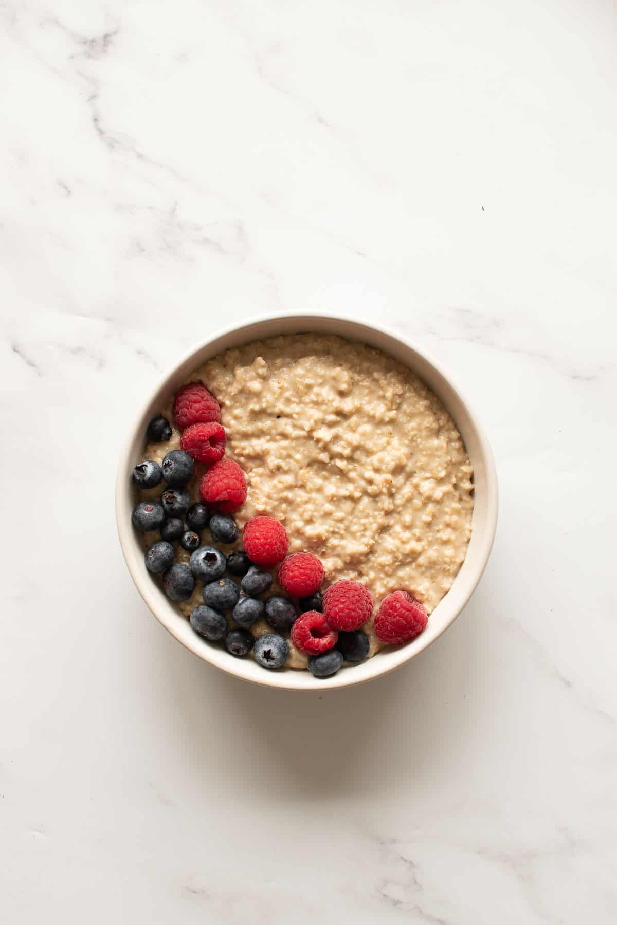 A bowl of protein oatmeal, topped with fresh berries.