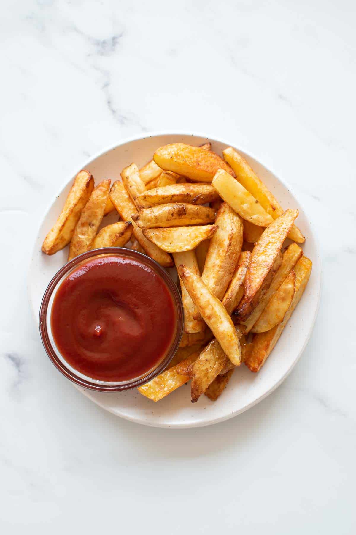 Homemade baked fries with ketchup.