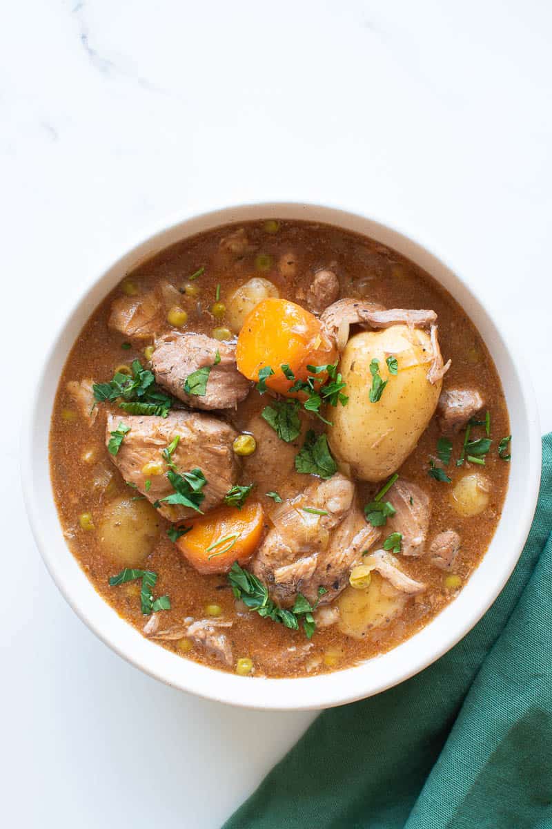 A bowl of slow cooker pork casserole with potatoes.