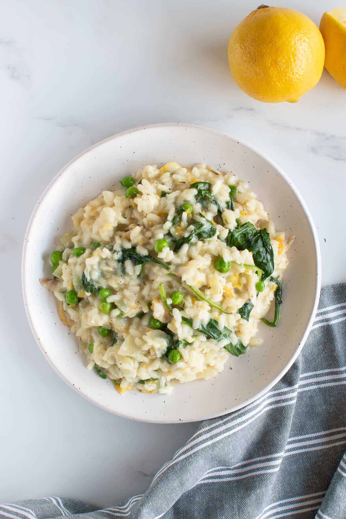 A plate with smoked haddock risotto, with lemon on the side.