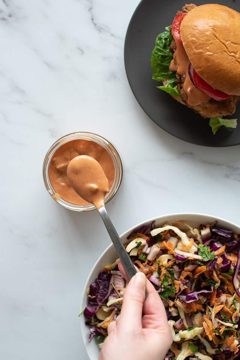 A spoon filled with burger sauce.