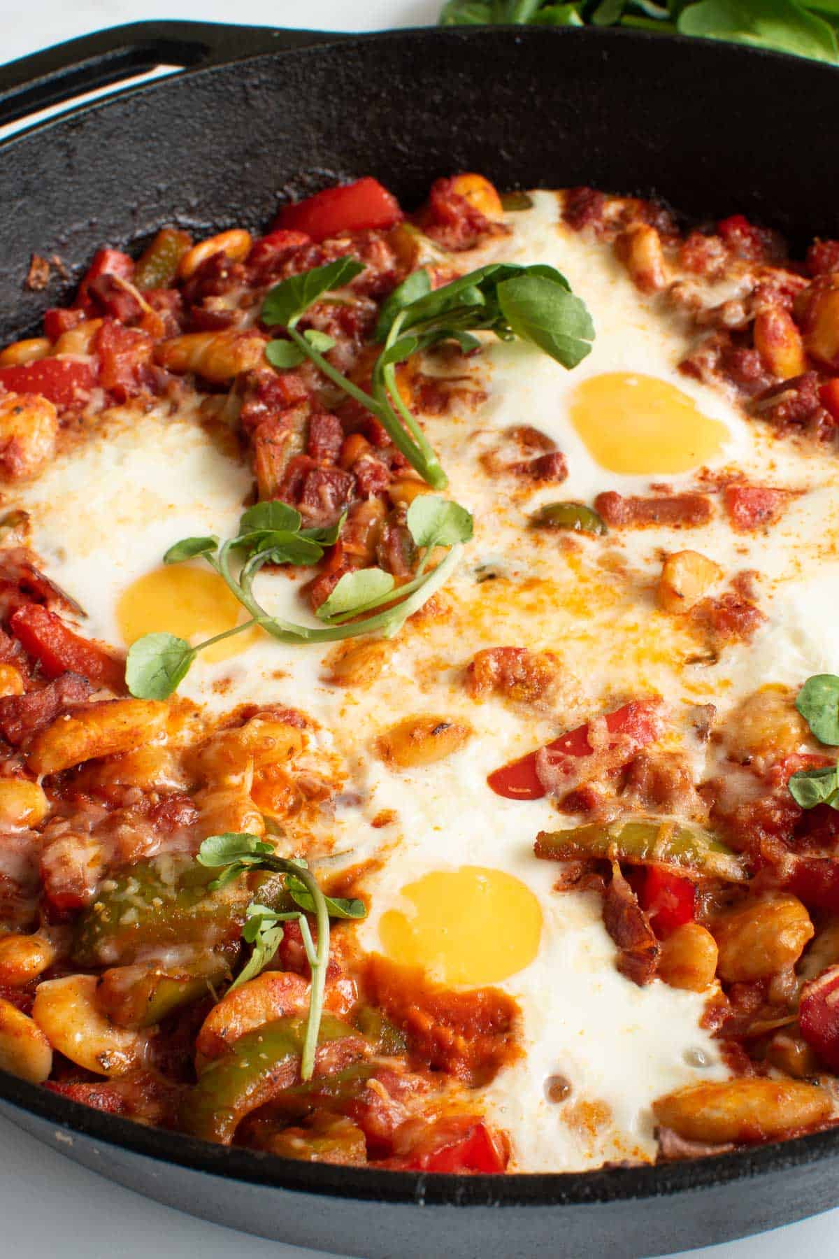 Close up of a skillet with baked eggs and chorizo.