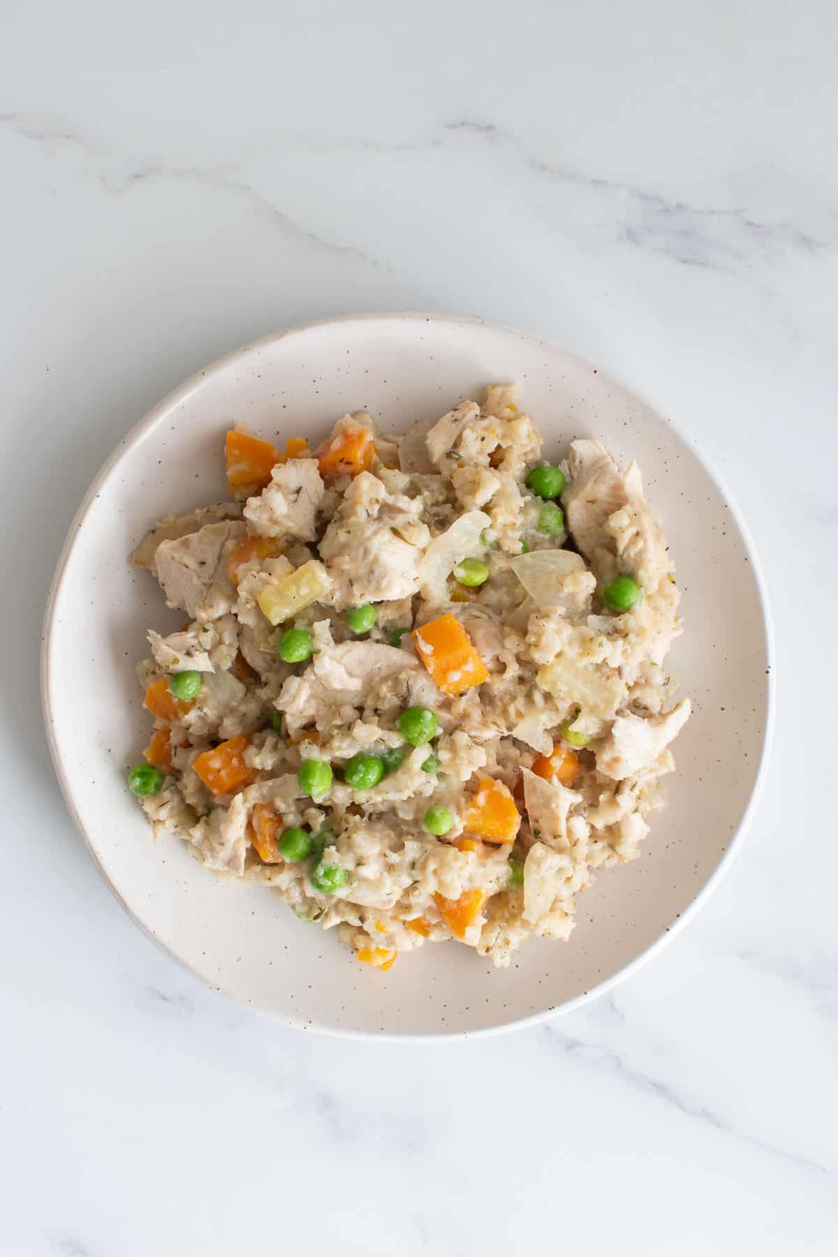 A plate with crockpot brown rice and chicken.