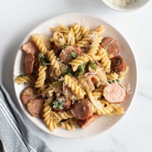 Pasta with kielbasa sausage on a plate.