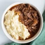 A bowl of shredded braising steak and mashed potatoes.
