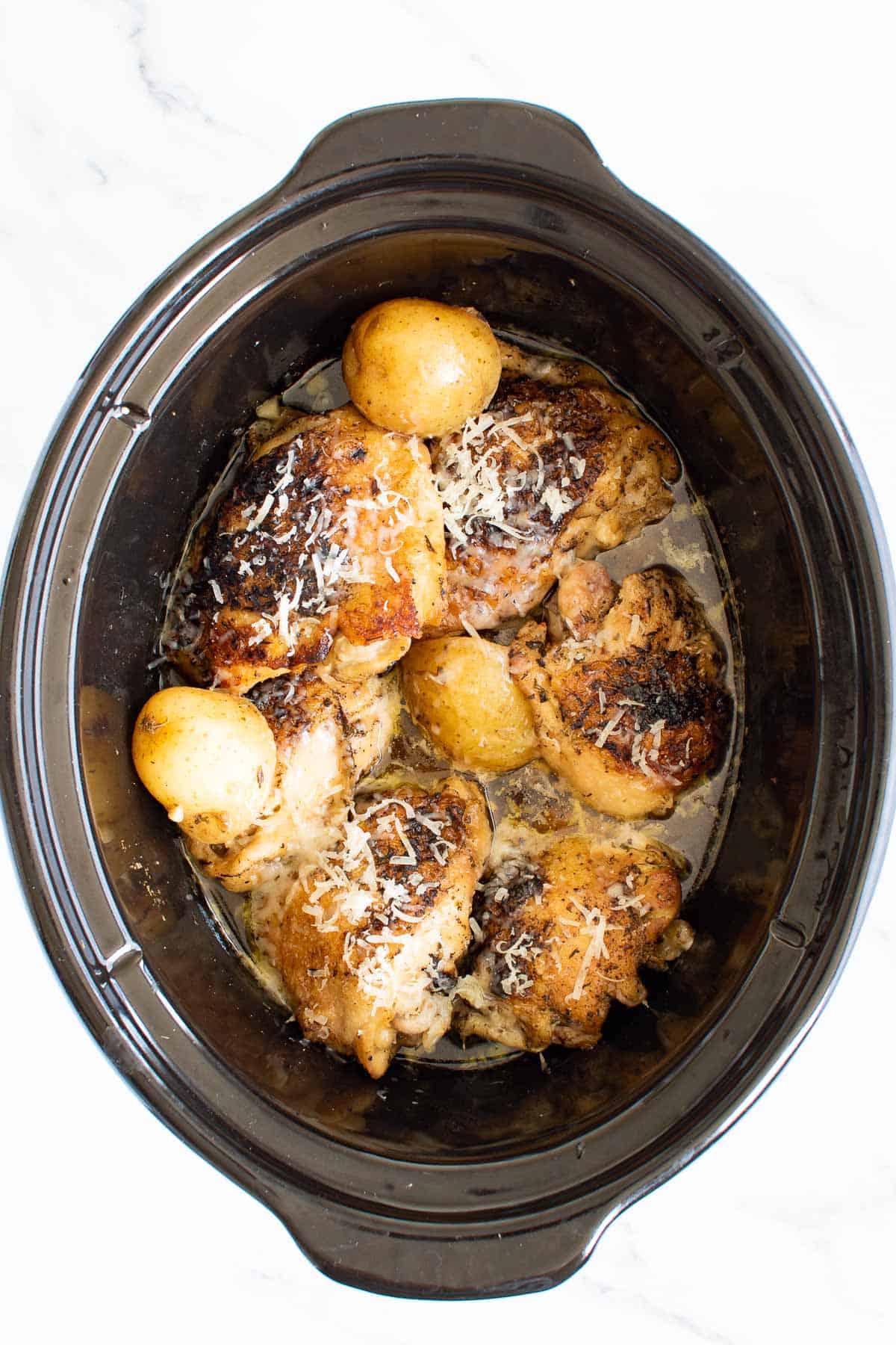 Chicken thighs and potatoes in a Crockpot.