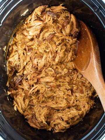 Shredded honey mustard chicken in a slow cooker.