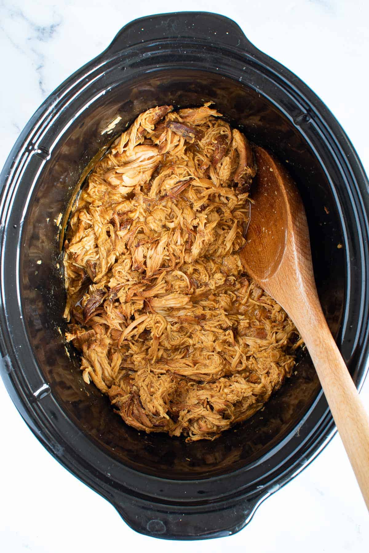 Shredded chicken with honey and mustard in a Crockpot.