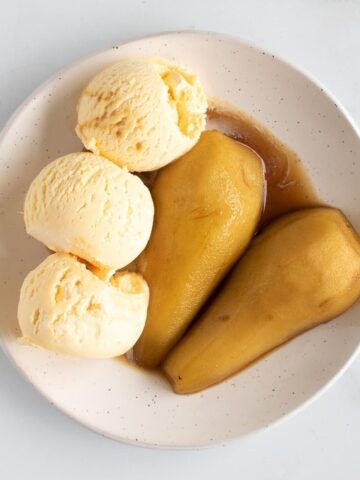 Brandied pears and ice cream on a plate.