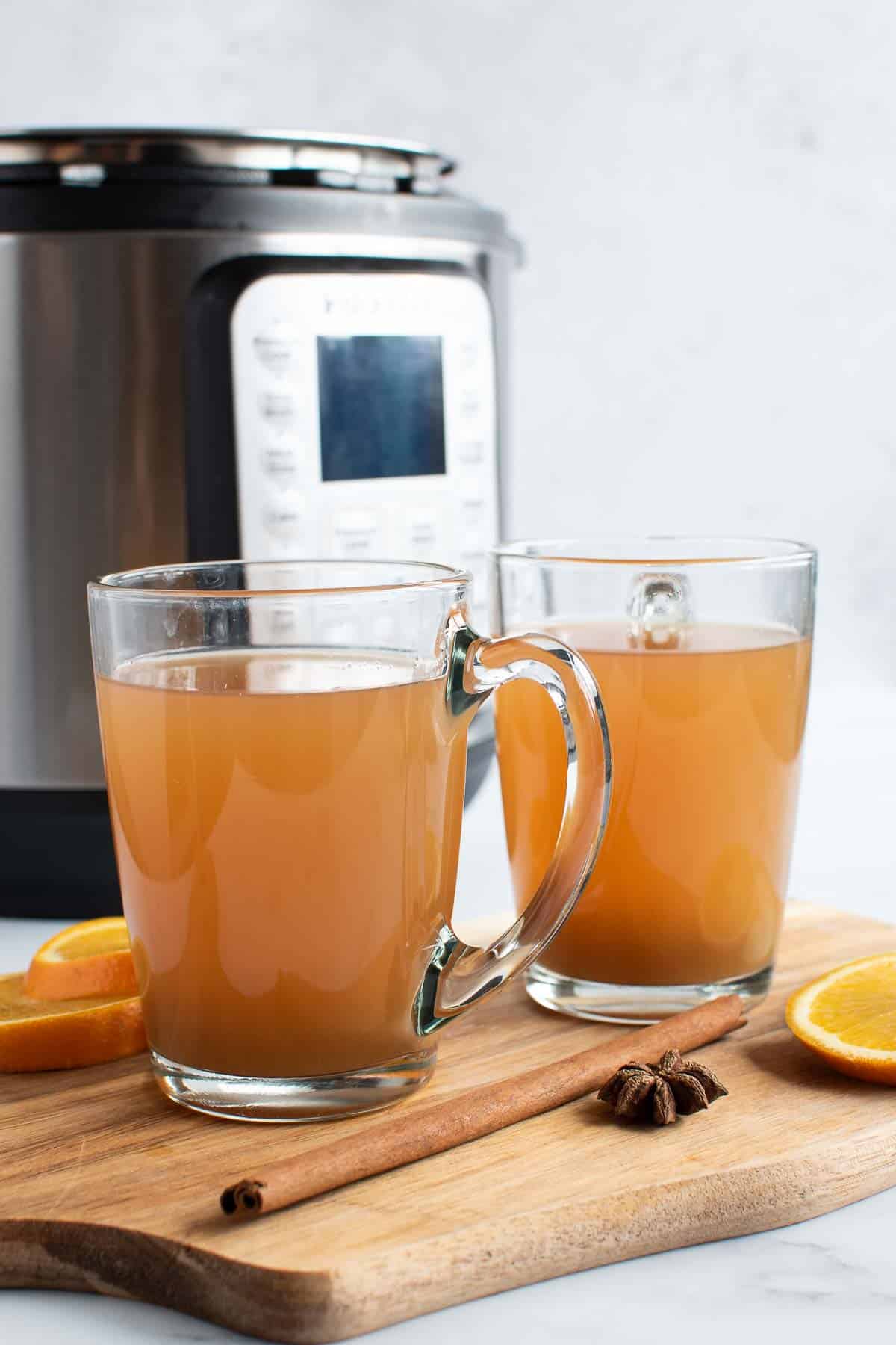 Apple cider in front of an Instant Pot.