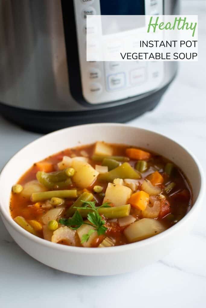 A bowl of vegetable soup in front of an Instant Pot.