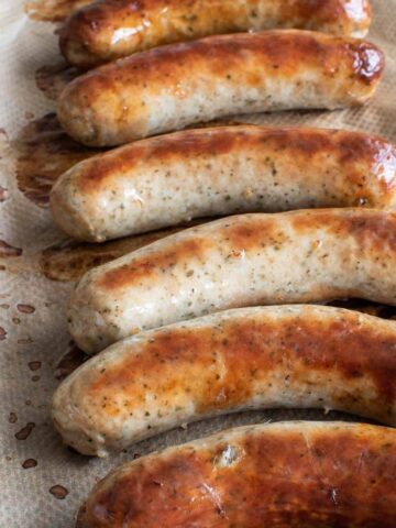 Baked bratwurst on a baking sheet.