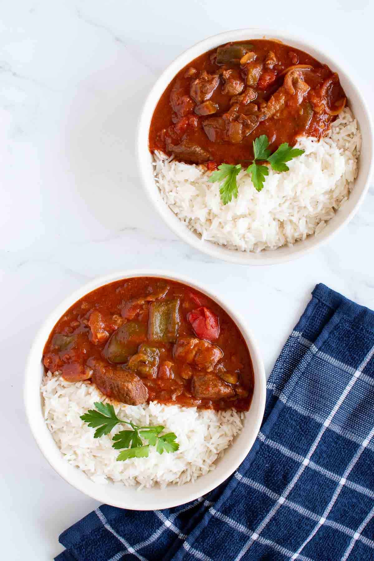 Two bowls of slow cooker beef goulash with rice.