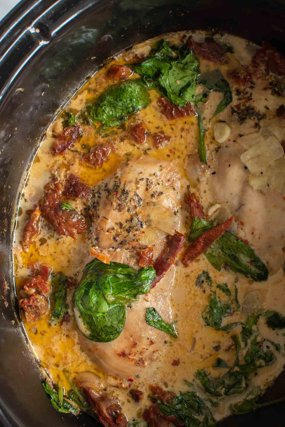 Close up of Tuscan chicken in a Crockpot.