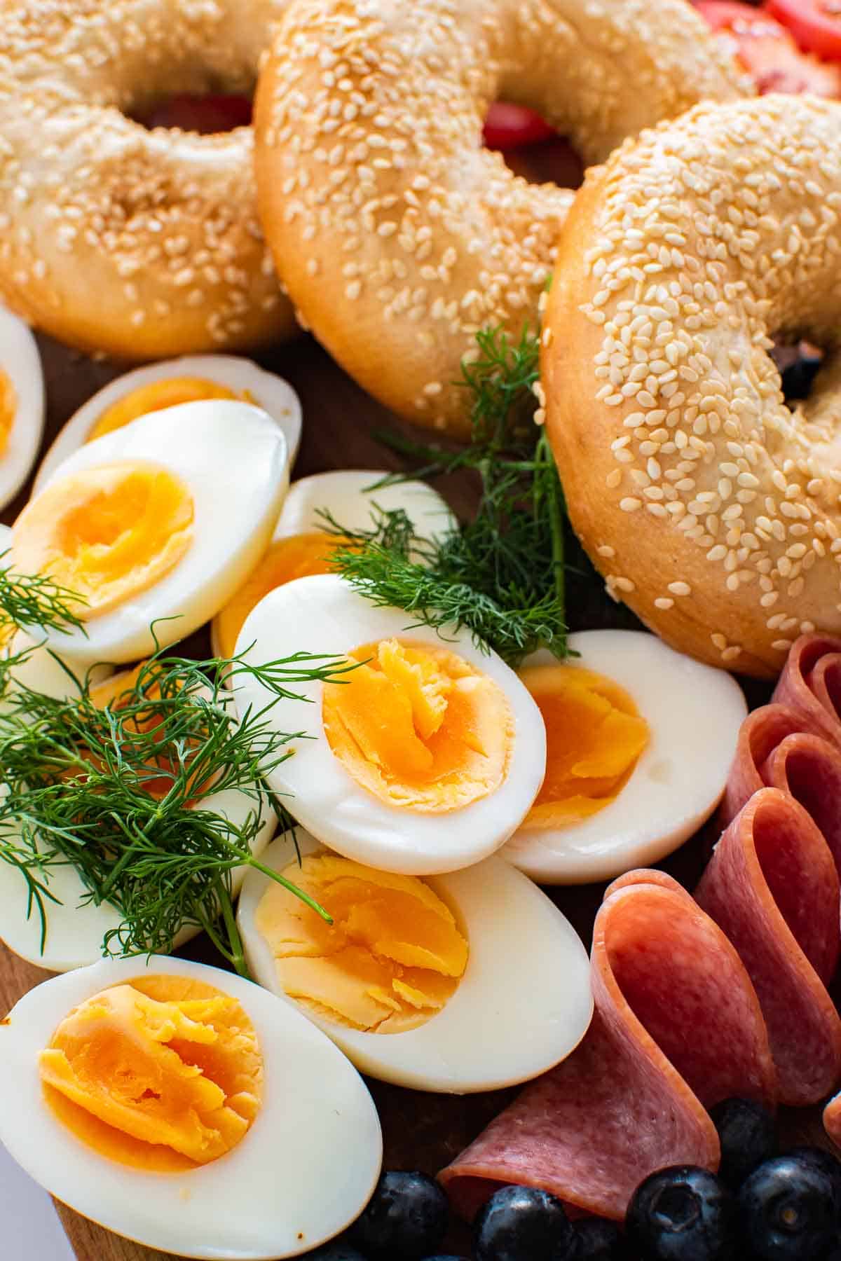 Close up of hard boiled eggs and bagels.