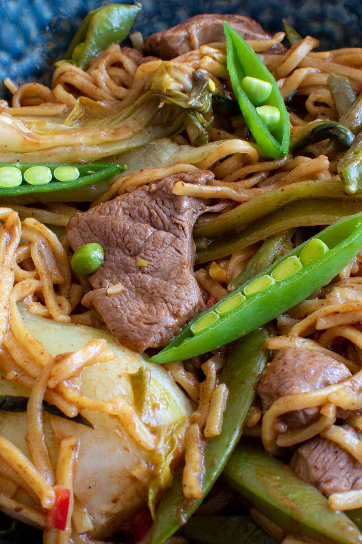 Close up of stir fry with sugar snap peas, bok choi and duck breast.