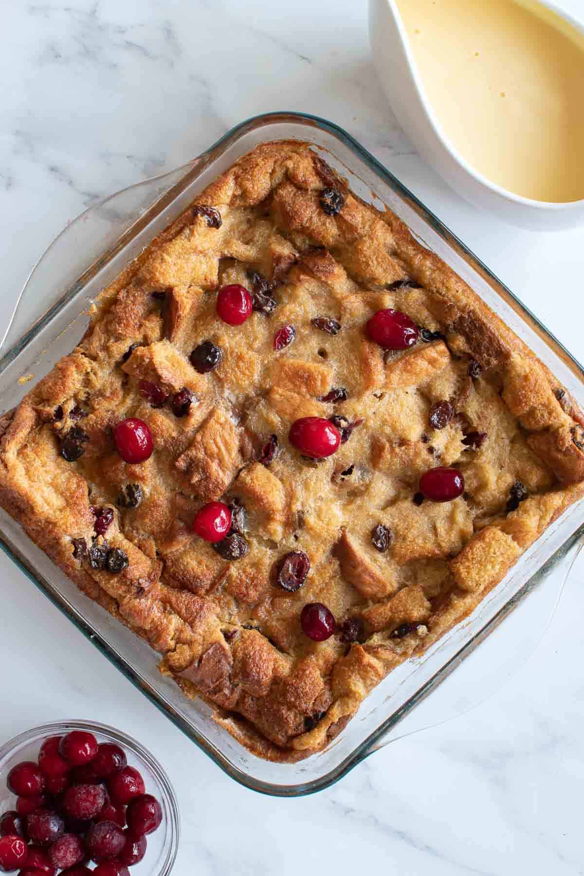 Bread pudding with eggnog, with cranberries and custard on the side.