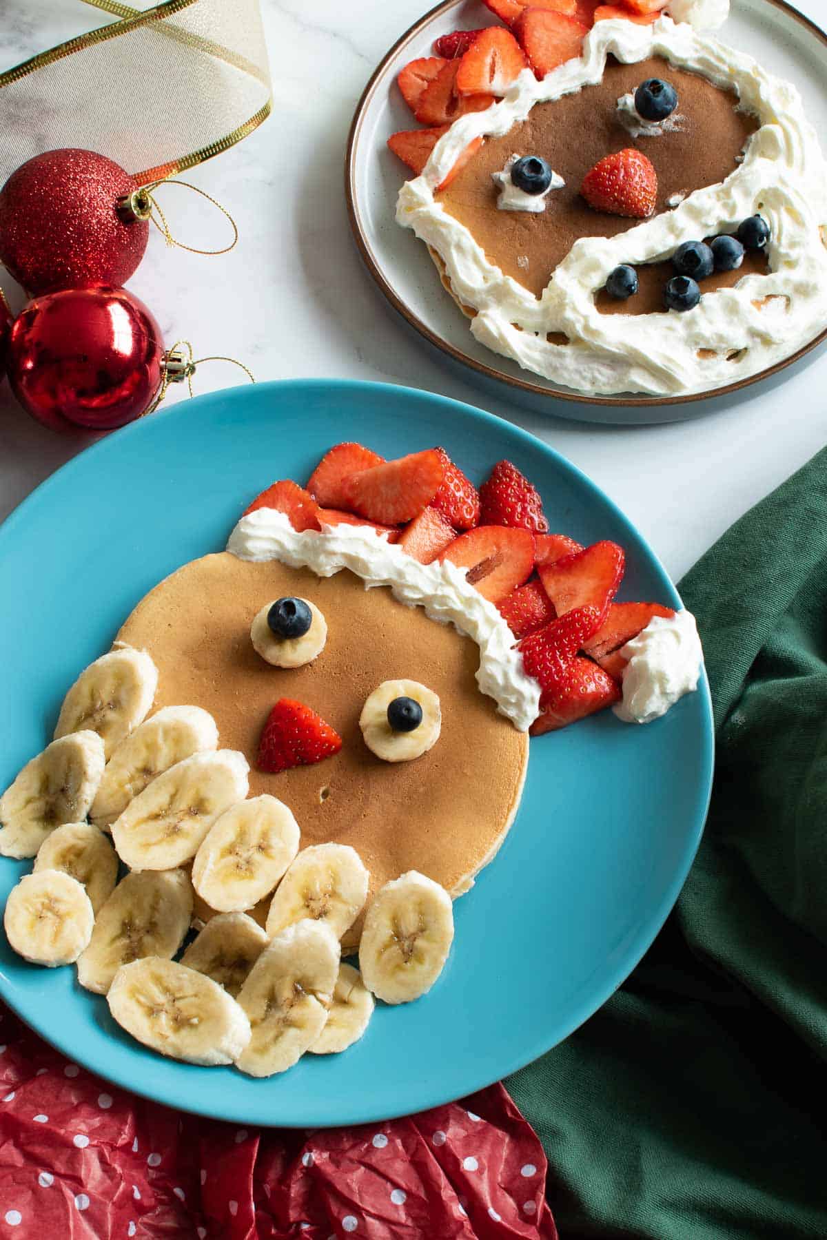 Santa pancakes for Christmas, with whipped cream, strawberries, bananas and blueberries.
