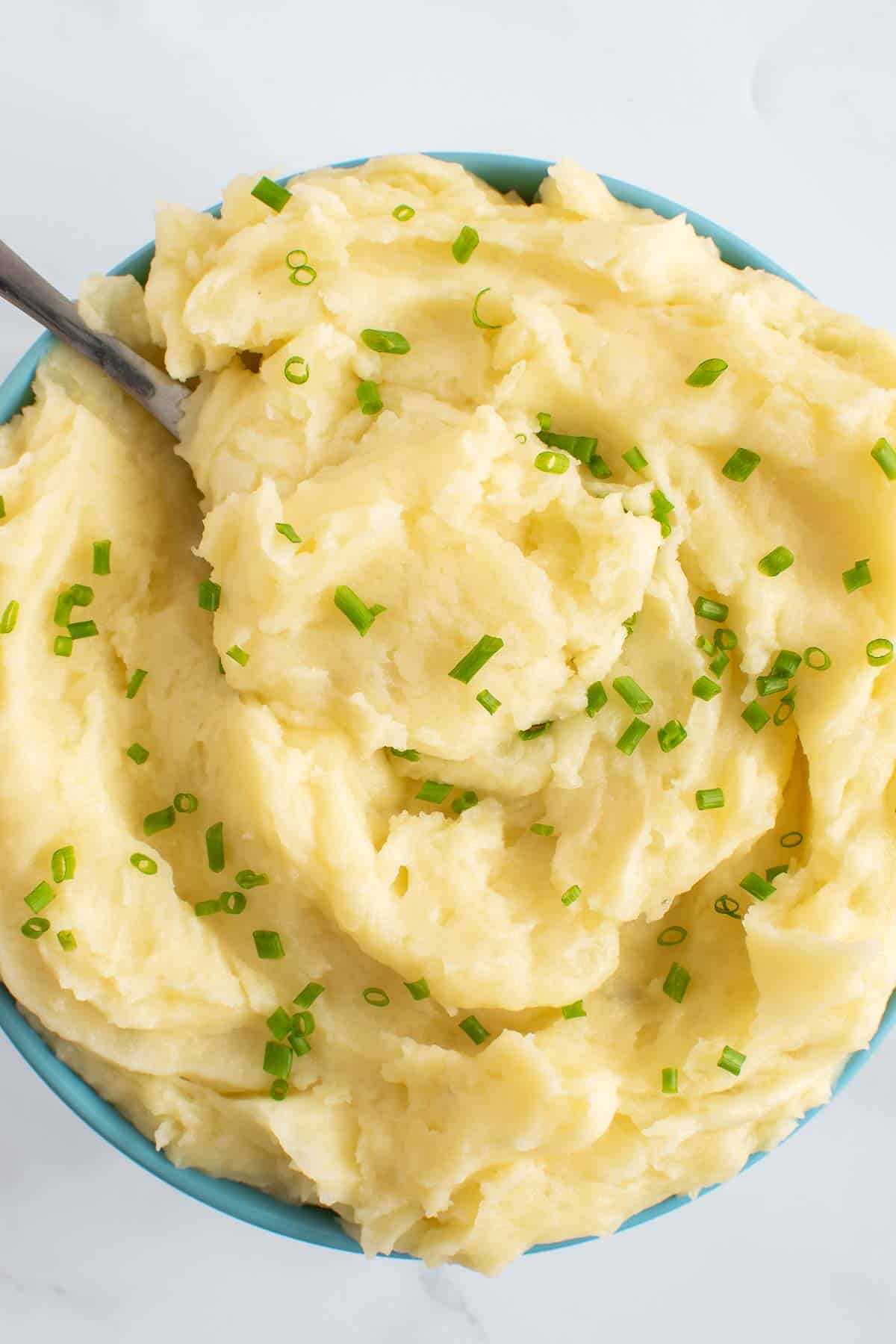 Creamy whipped potatoes garnished with chives.