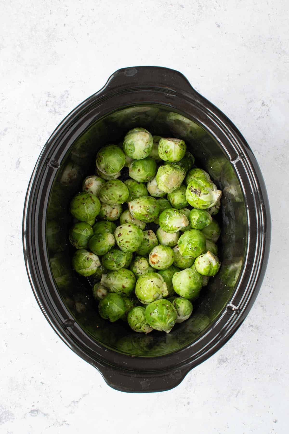 Seasoned brussels sprouts in a crockpot.