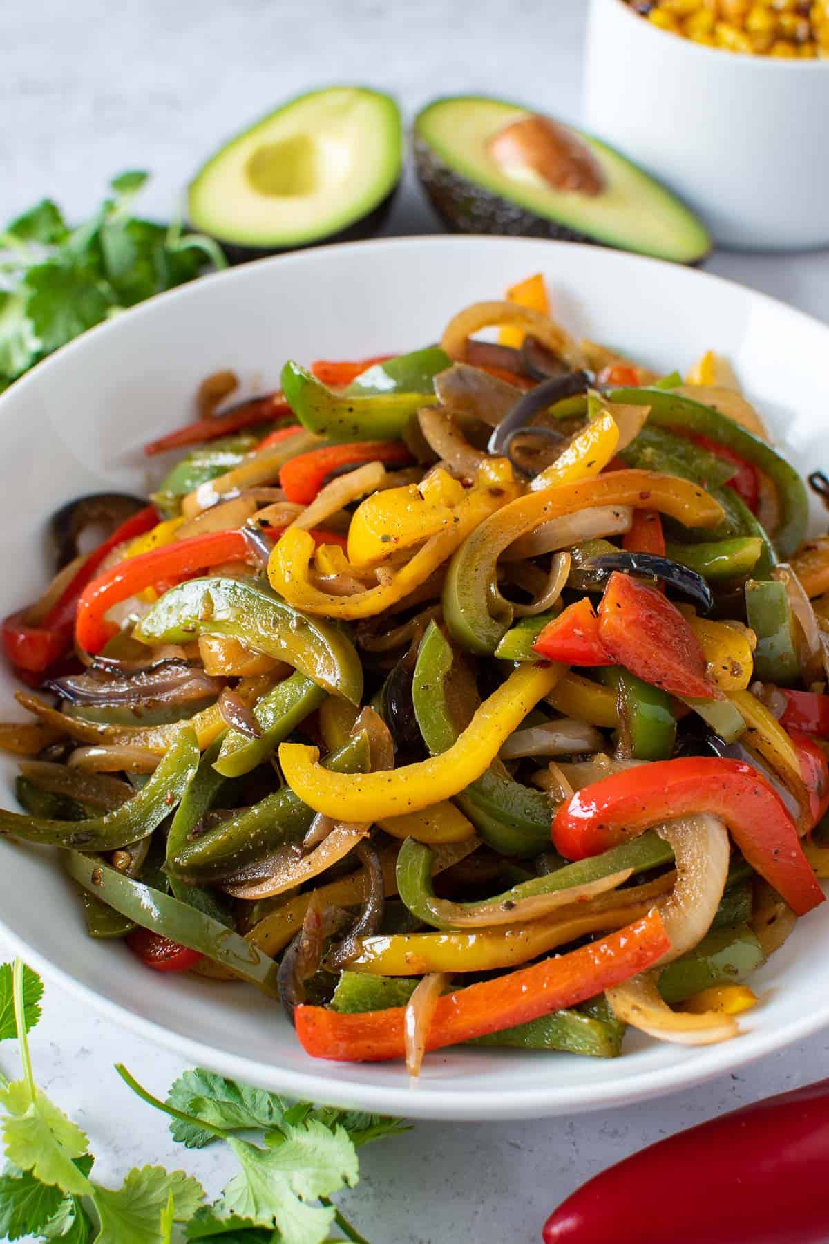 Pan seared peppers and onions, with avocado and cilantro on the side.