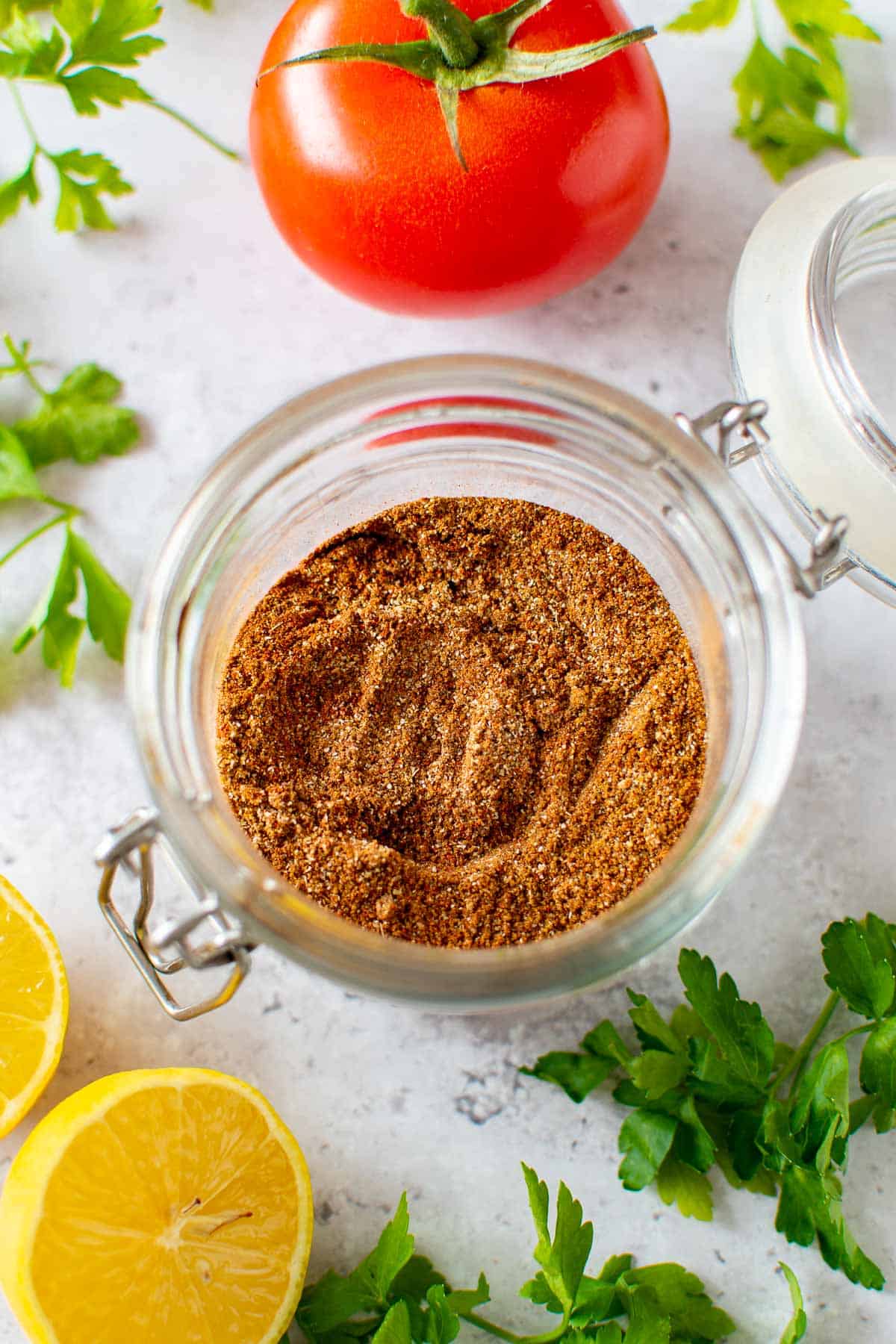 Shawarma spice mix in a jar, with vegetables on the side.