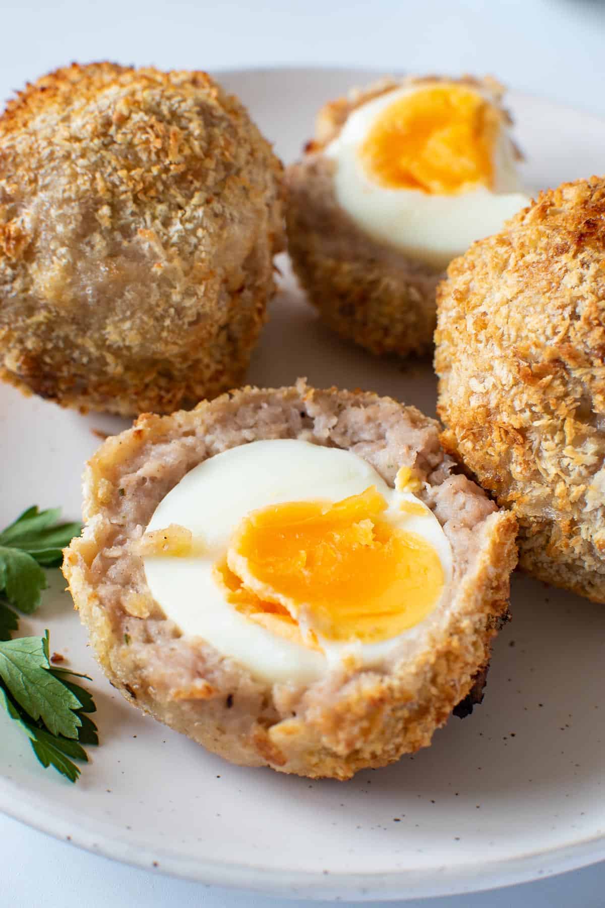 Air fried scotch eggs on a plate.