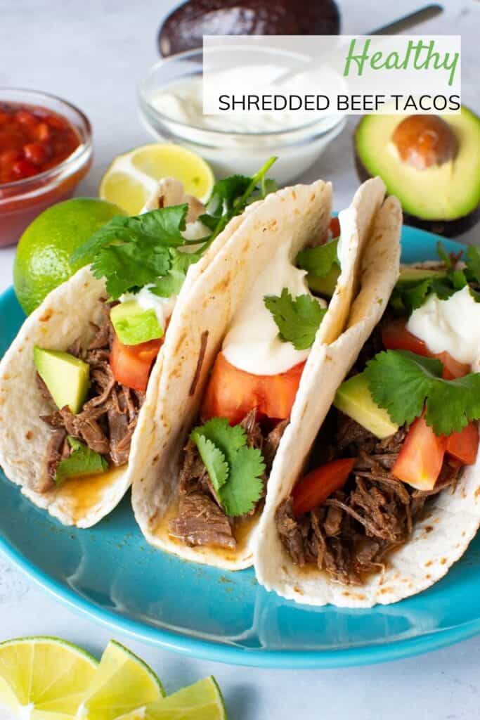 Shredded beef tacos on a plate.