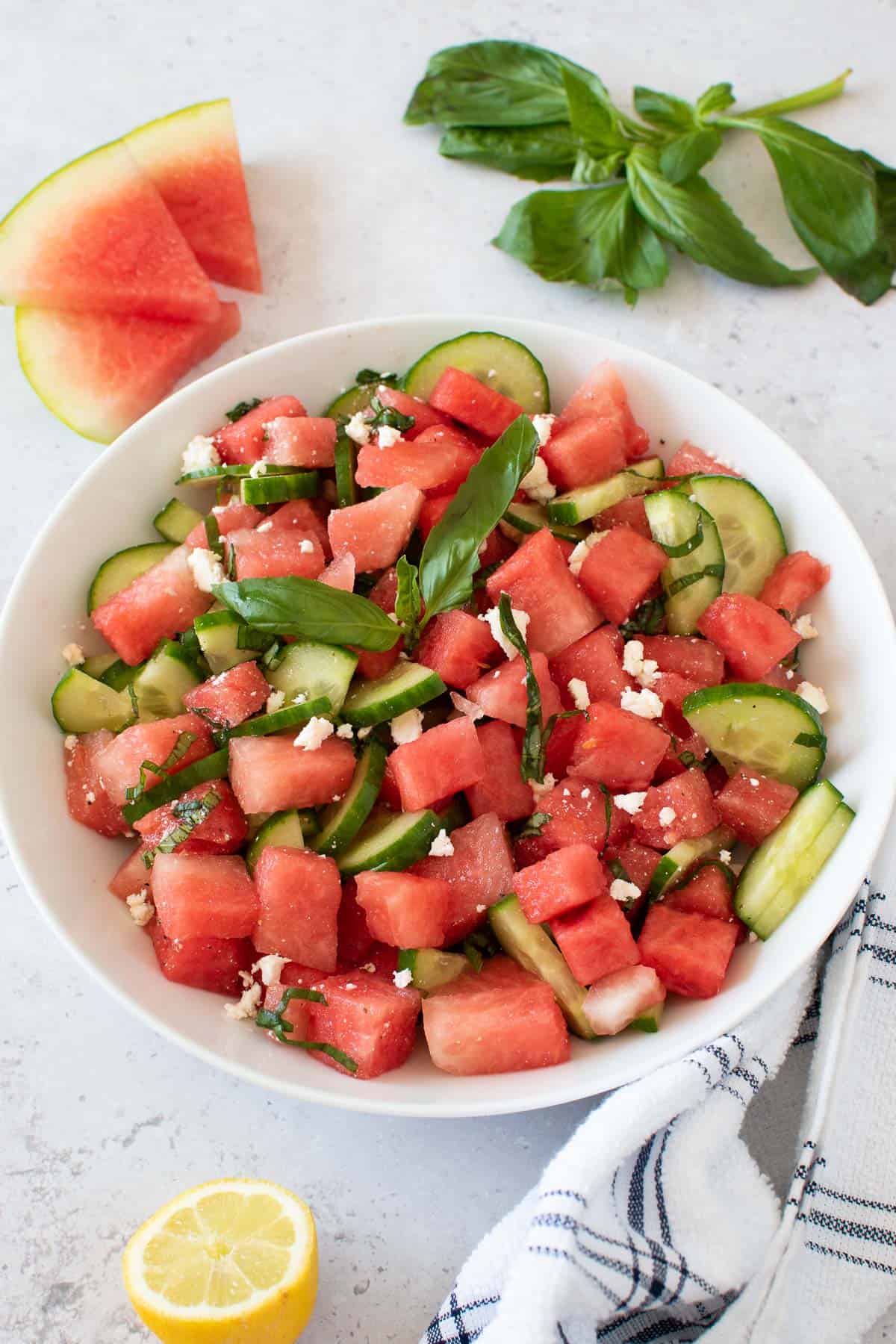 Watermelon, feta and basil salad in a white bowl.