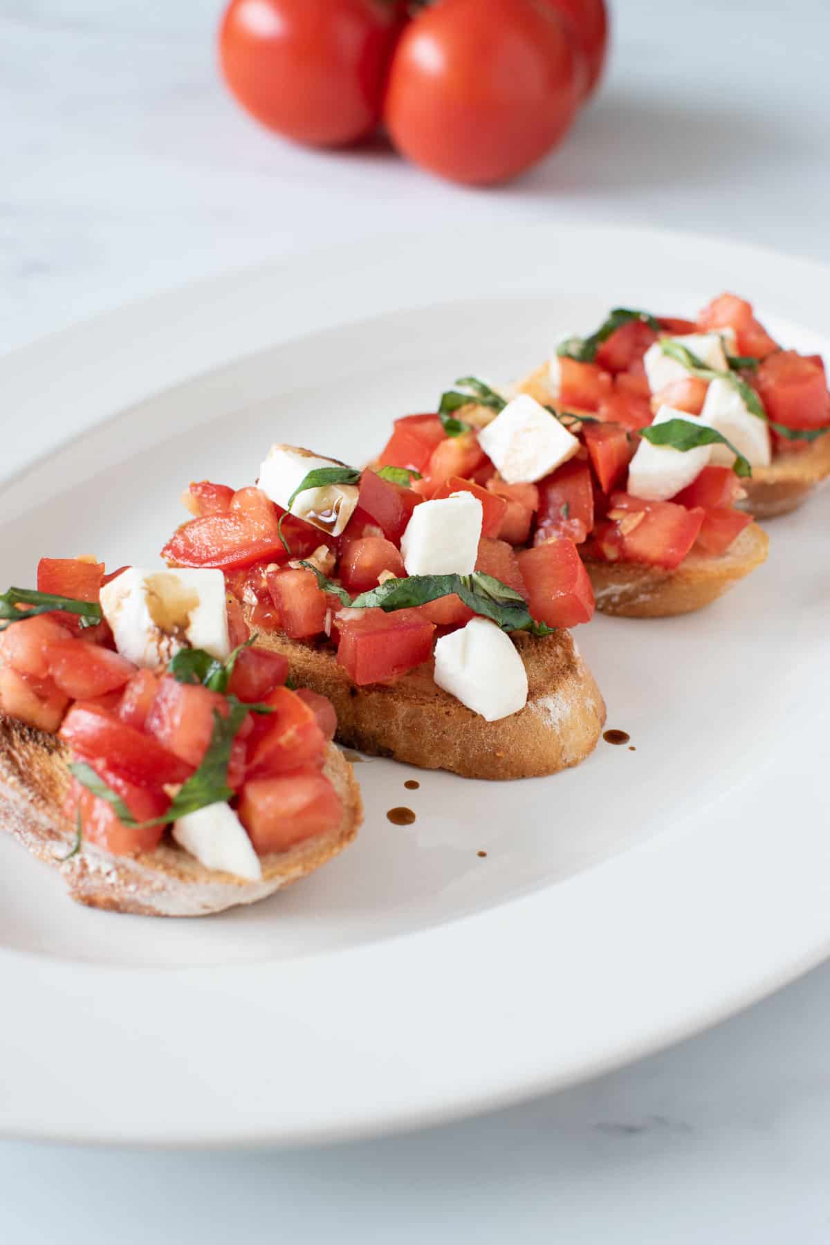 Tomato and mozzarella toasts on a plate.