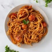 Spicy harissa pasta with tomatoes and onions.