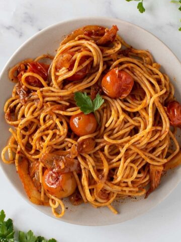 Spicy harissa pasta with tomatoes and onions.