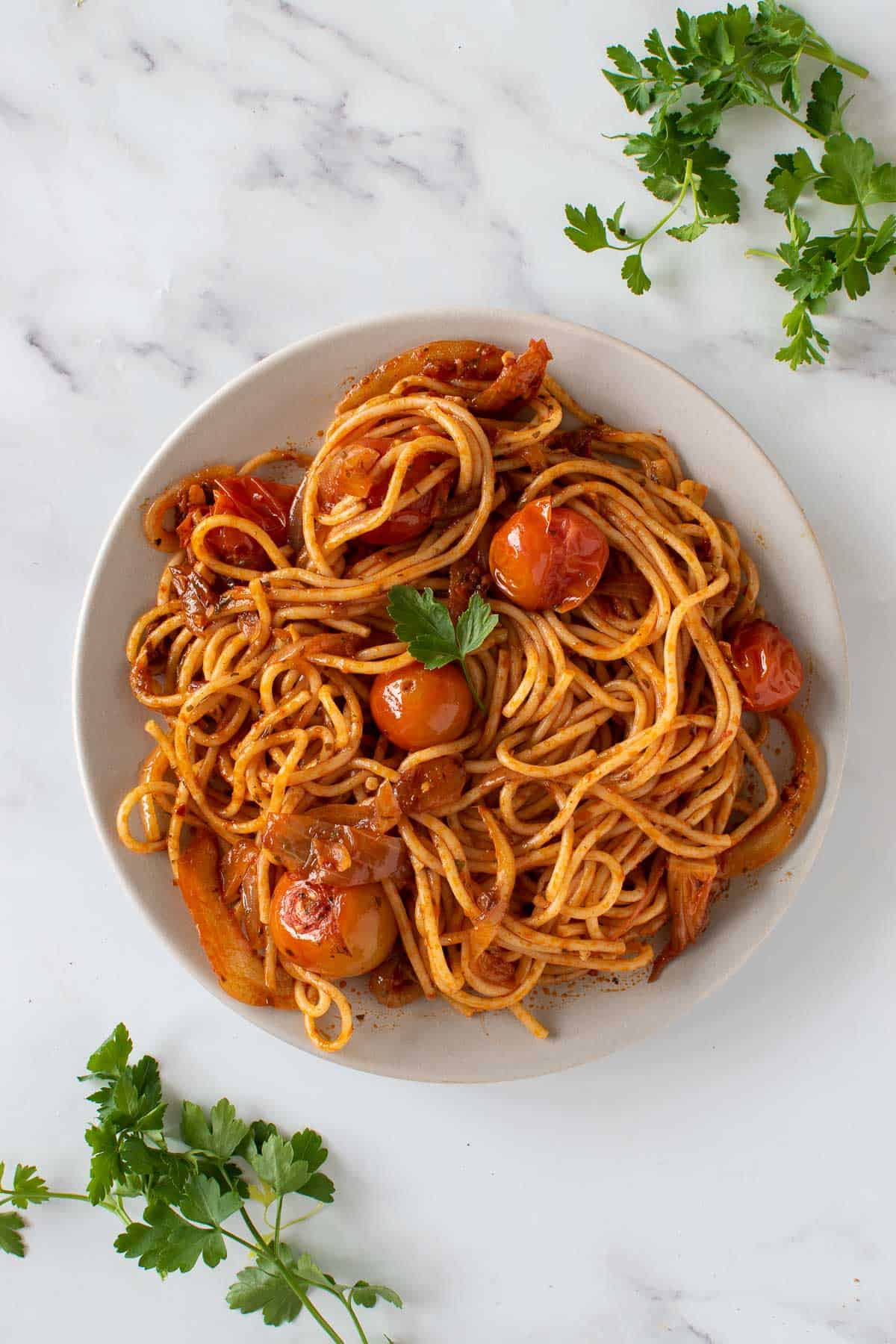 A plate of harissa pasta, garnished with parsley.